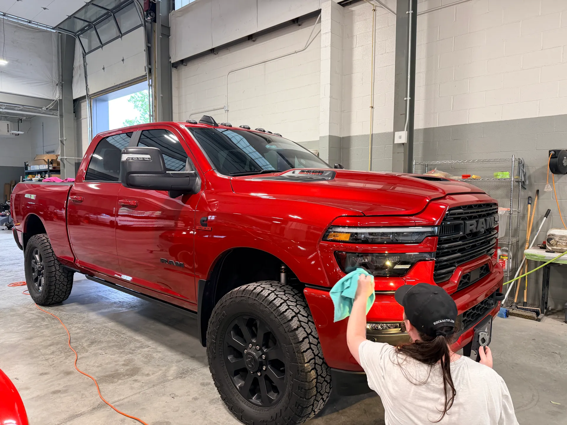 A red pickup being wiped down by hand in our detail bay.