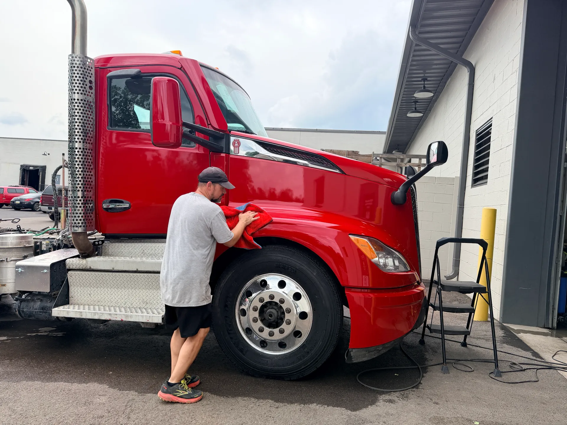 A red tractor cab getting a hand wash outside our bay.