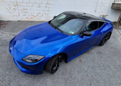 A red sports car being detailed by a professional at Total Detailing Auto Spa.