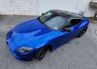 Red car getting detailed by a professional at Total Detailing Auto Spa.