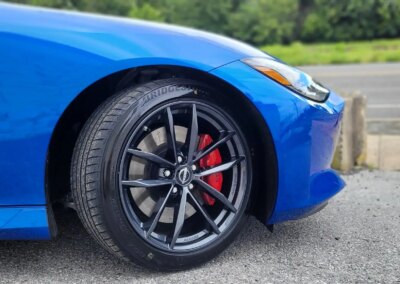 A black car with shiny, detailed finish parked in a garage.