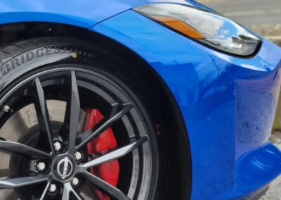 A car getting detailed by a worker with equipment at Total Detailing Auto Spa.