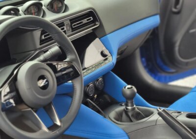 A shiny black car after detailing with a reflection on the hood.