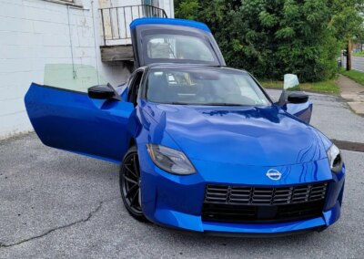 A person detailing a car's interior with a vacuum cleaner.