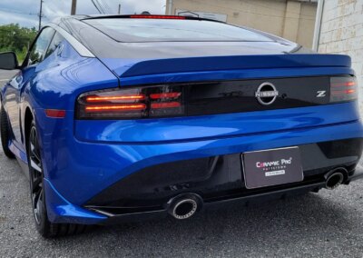 A shiny black car after detailing service with a clear reflection on its hood.