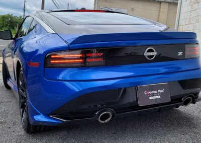 A car undergoing detailing in a garage with equipment and products nearby.