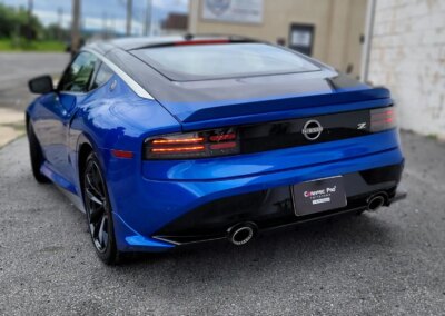 A freshly detailed car with shiny black paint and chrome wheels.