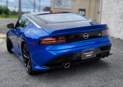 A detailed car interior being cleaned with a brush and vacuum by a professional.