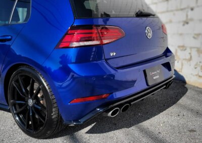 A clean, shiny red sports car parked outdoors on a sunny day