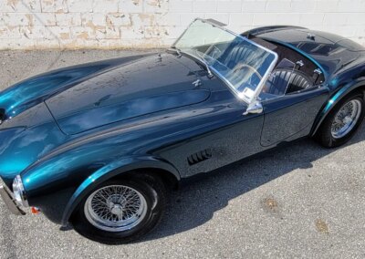 A shiny black car with open doors being detailed by a professional at Total Detailing.