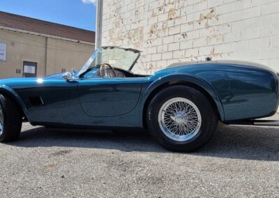 A shiny black car after detailing service with a reflection on its hood.