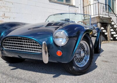 A car getting detailed inside a garage with equipment and cleaning products visible.