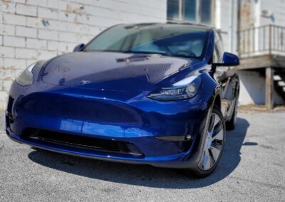 A silver car being washed with soap foam at a car detailing service.