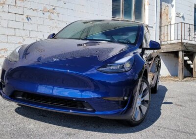 A black SUV with shiny, clean exterior parked on a concrete driveway.