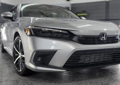 A car with open doors being detailed at Total Detailing shop.