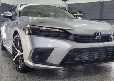 A car with open doors being detailed by a professional at Total Detailing Auto Spa.