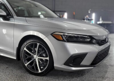 A car with its front hood and doors open during a detailing service.