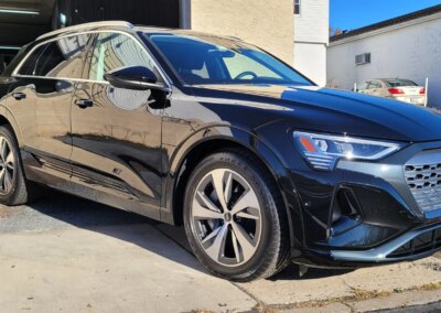 A car with open doors being detailed by a professional at Total Detailing.