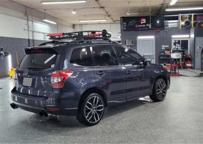 A silver Subaru Forester with new window tint parked outdoors.