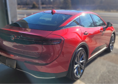 Car detailing tools and products on a shelf in a workshop.