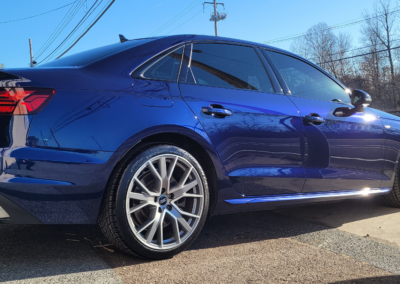 Red sports car being detailed by a professional at Total Detailing shop.