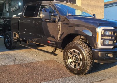 A shiny black car with a polished finish after detailing.