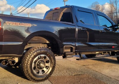 A man detailing a car's interior with a cleaning tool.