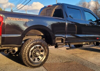 A car being detailed by a professional with cleaning equipment.