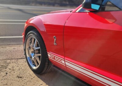 A car being washed with foam and water at a detailing service.