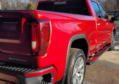 Car detailing service with a worker polishing a black car