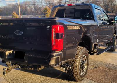A black Ford Tremor pickup truck parked on a street.