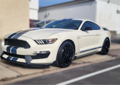 A red car being washed and detailed with soap and water.