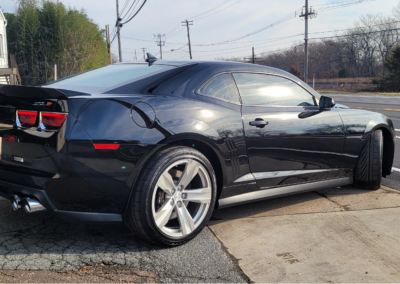 A car being detailed by a professional with cleaning equipment.