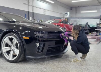 A car undergoing detailing services in a well-equipped garage.