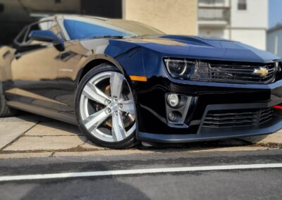 A red sports car being detailed in a garage.