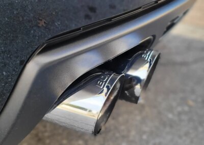 A clean and polished black car parked in a detailing garage.