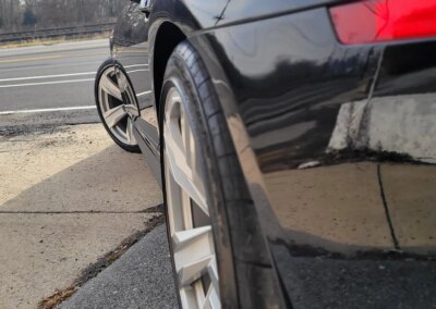 A clean and shiny black car after detailing service.