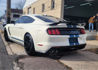 Logo of Total Detailing with blue and white car silhouette on a black background